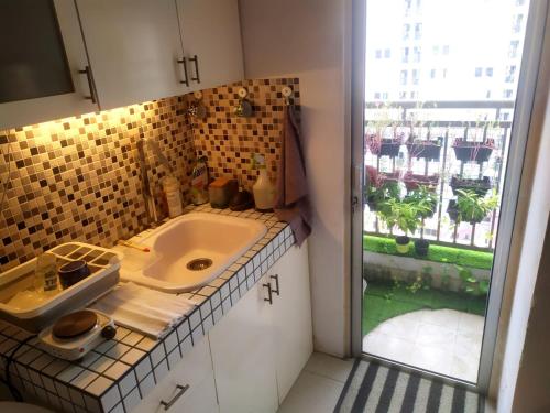 a bathroom with a sink and a large window at Tiny studio with pool, jogging track, gym and Mall in Jakarta