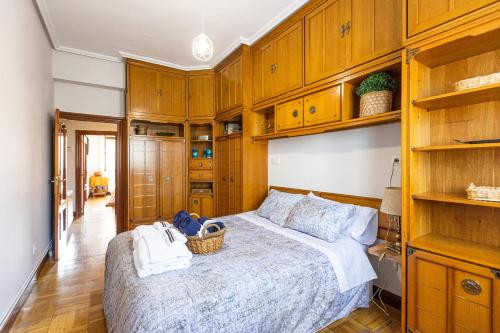 ¡Recién publicado!Amezola - Bilbao في بلباو: غرفة نوم بها دواليب خشبية وسرير كبير
