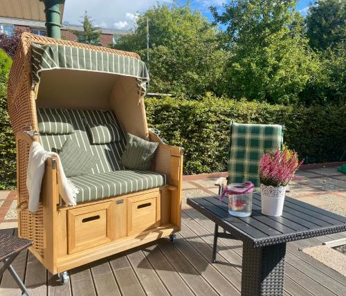 einen Korbstuhl und einen Tisch auf einer Terrasse in der Unterkunft Inselferien Micheel in Burg auf Fehmarn