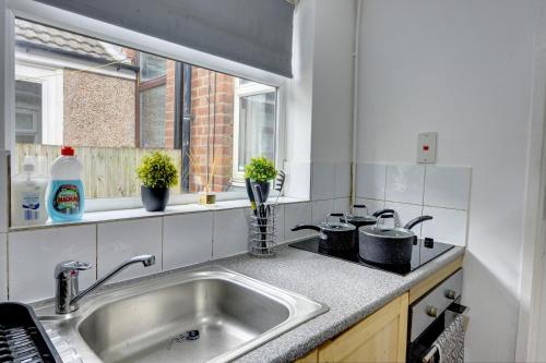 a kitchen with a sink and a window at Cheerful 3 Bedroom Home, Sleeps 6 Guest Comfy, 1x Double Bed, 4x Single Beds, Free Parking, Free WiFi, Suitable For Business, Leisure Guest,Coventry, Midlands in Coventry