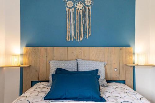 Reve bleu في مونتوبان: غرفة نوم بسرير مع جدار ازرق