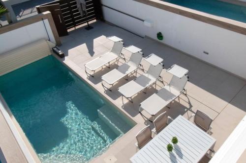 a group of chairs and a swimming pool at Magnifique villa avec piscine privée chauffée in Benijófar