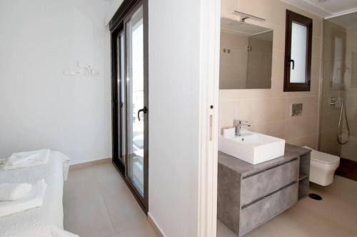 a bathroom with a sink and a toilet and a mirror at Magnifique villa avec piscine privée chauffée in Benijófar
