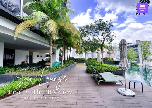 a resort with a pool with tarps and palm trees at Continew Residences TRX Lux Pool View in Kuala Lumpur