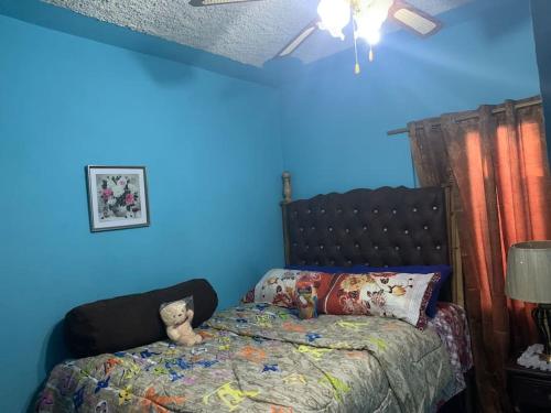 un dormitorio con una cama con un osito de peluche sentado en ella en Forrest Family Property, en Kingston