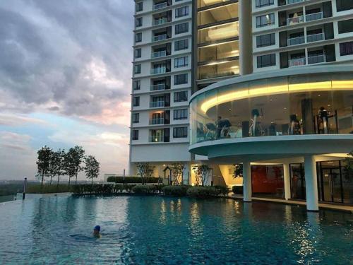 uma pessoa numa piscina ao lado de um edifício em WOODSBURY PREMIER LUXURY SUITE 2B2R 2MIN SUNWAY em Butterworth