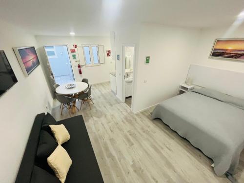 1 dormitorio con cama, mesa y escritorio en Lisbon Ocean Apartments, en Costa da Caparica