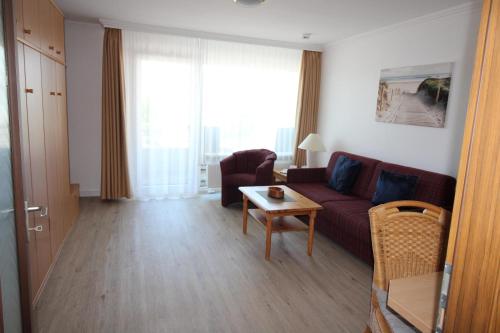 a living room with a couch and a table at Haus Norderhoog Wohnung 39 in Westerland
