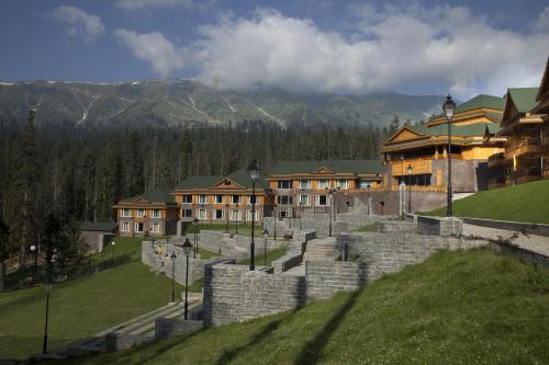 a group of buildings with mountains in the background at The Khyber Himalayan Resort & Spa in Gulmarg