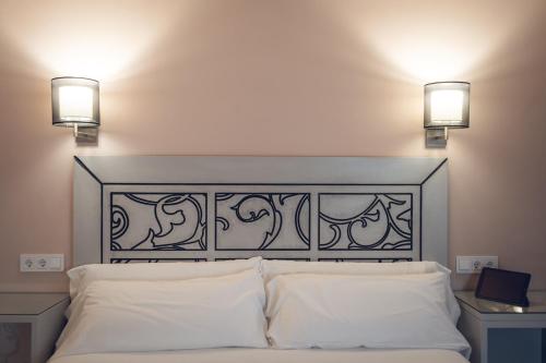 a bed with two lights on top of it at Hostal Los Castañuelos in Candeleda