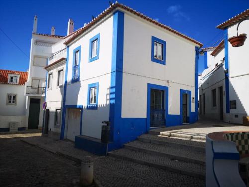 a white and blue building with blue doors at Refugio dos Lima in Ericeira