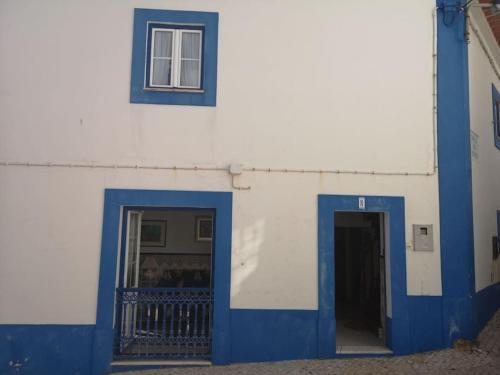a blue and white building with a door and a window at Refugio dos Lima in Ericeira