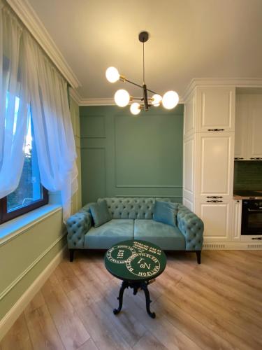 a living room with a blue couch and a table at Classic and New brand Apartment San Stefano 9 in Varna City