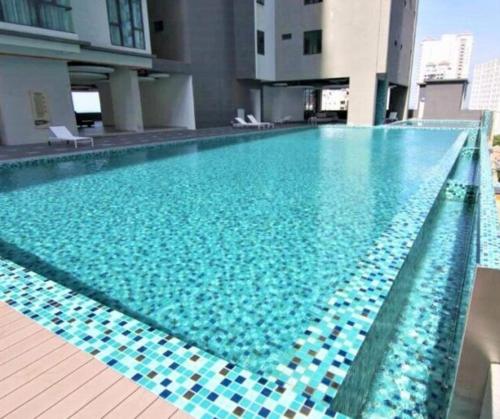 a large swimming pool with blue water in a building at Jazz Service Suites 2 bedroom 35-1 by Yen's Sojourn in Bagan Jermal