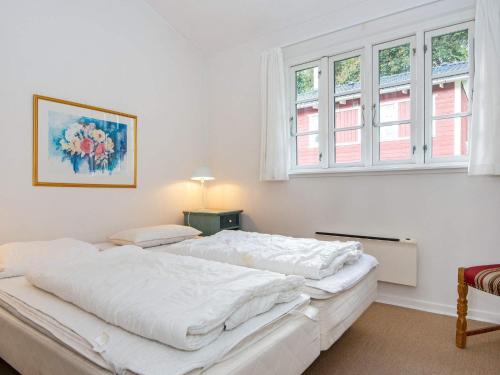 biała sypialnia z 2 łóżkami i 2 oknami w obiekcie Three-Bedroom Holiday home in Aabenraa 6 w mieście Danland Løjt