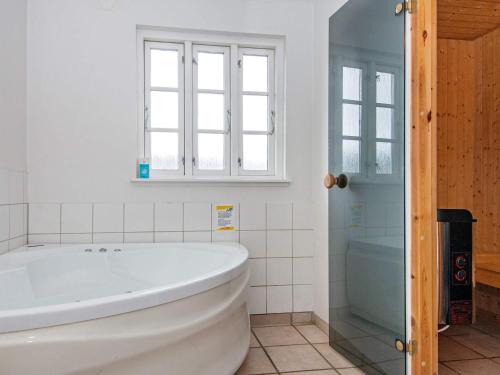 Danland LøjtにあるThree-Bedroom Holiday home in Aabenraa 6の窓付きのバスルーム(白いバスタブ付)