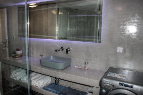 a bathroom with a sink and a washing machine at Fiskardo Beach House in Fiskardho