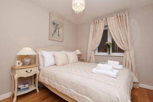 a bedroom with a white bed and a window at Three Bedroom Apartment by Beautiful Park in London