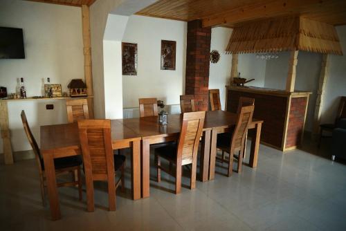ein Esszimmer mit einem Holztisch und Stühlen in der Unterkunft Pensiunea Lucica in Vişeu de Jos