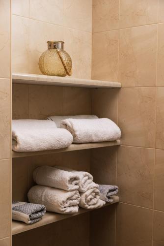 a bathroom with shelves with towels on them at Villa Emmanouela in Pitsidia