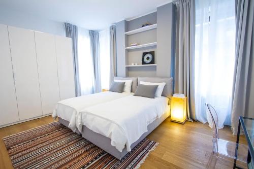 ein Schlafzimmer mit einem weißen Bett und einem großen Fenster in der Unterkunft Easylife - Annydi Art Home in Duomo in Mailand