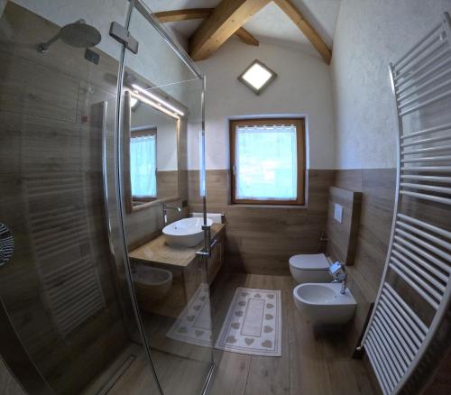 a bathroom with two sinks and a shower and a toilet at Casa Betty in Bormio