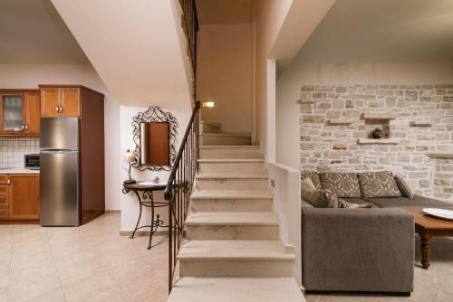 a staircase in a living room with a stone wall at Villa Emanuela in Pitsidia