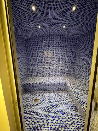a blue tiled shower room with a blue tile floor at Wonderful Reva Aparthotel Downtown in Dubai