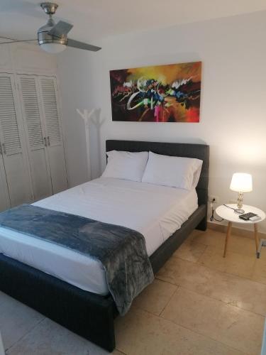 a bedroom with a bed and a painting on the wall at Cabrero Beach 1111 in Cartagena de Indias