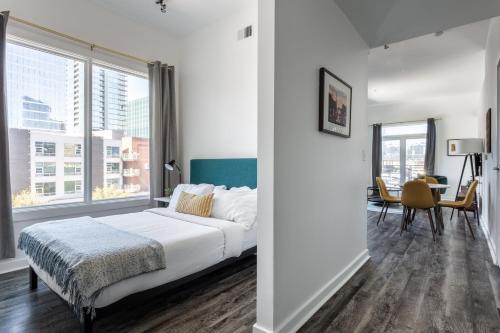 a bedroom with a bed and a large window at Locale Lofts The Gulch - Nashville in Nashville