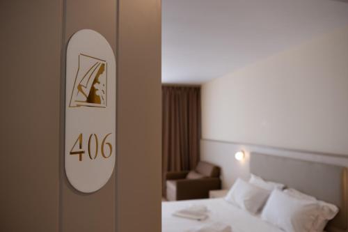a hotel room with a bed and a mirror on a door at Fllad Resort & SPA Durres in Golem