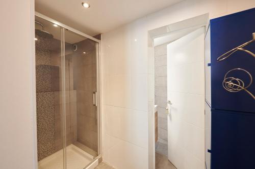 y baño con ducha a ras de suelo y puerta de cristal. en Artist's Loft in the centre of Santa Cruz, en Santa Cruz de Tenerife