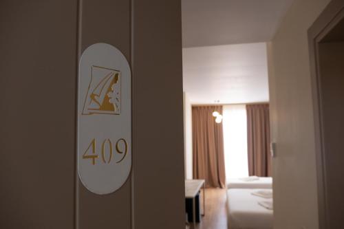 a hotel room with a sign on a door at Fllad Resort & SPA Durres in Golem