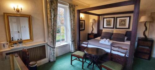 a bedroom with a bed and a table and a window at Hook House in Hook