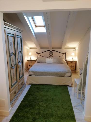 a bedroom with a bed and a green rug at Tana Bianca in Trieste
