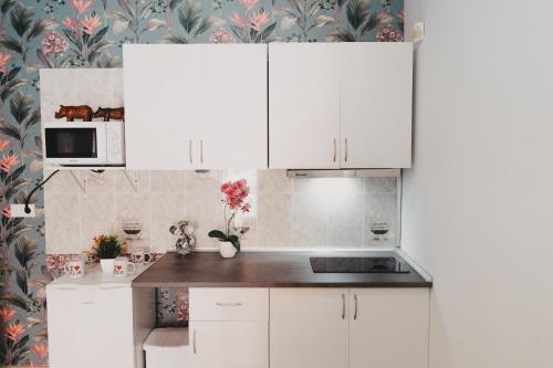 a kitchen with white cabinets and floral wallpaper at Miriam Costa de la luz 2 in Jerez de la Frontera