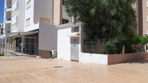 a white building with a sign on the side of it at Appartement la perle de Nouaceur in Nouaceur