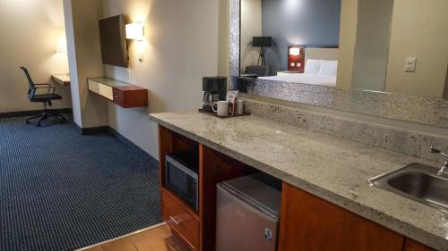 a kitchen with a sink and a bed in a hotel room at Best Western Santorin in Ciudad Victoria