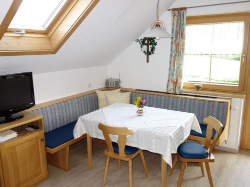 a room with a table and chairs and a tv at Haus Bauer Appartment II mit Balkon in Mariapfarr