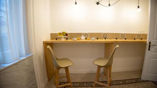 eine Küche mit zwei Stühlen und einer Theke mit Obst darauf in der Unterkunft Petrarca Suite in Palermo