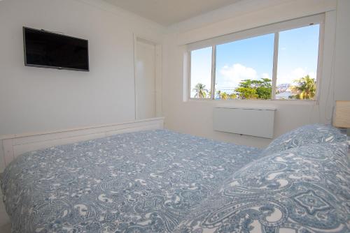 a bedroom with a bed and a flat screen tv at By The Sea Guest House in San Andrés