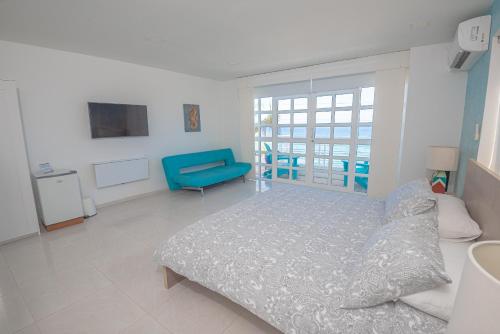 a bedroom with a bed and a blue chair at By The Sea Guest House in San Andrés