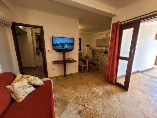 a living room with a couch and a flat screen tv at Espaço Nova Era Pousada in Jericoacoara