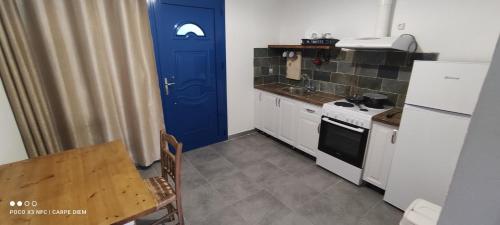 a small kitchen with a blue door and a table at Carpe diem in Galatas