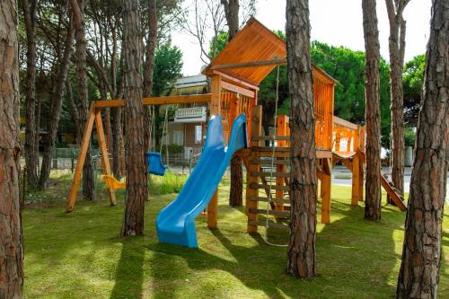 a playground with a blue slide and trees at Fllad Resort & SPA Durres in Golem