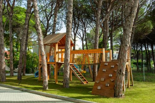 a playground with a tree house and a slide at Fllad Resort & SPA Durres in Golem