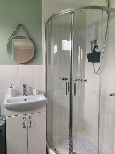 a bathroom with a shower and a sink and a mirror at Hugo's hideaway, Belle Aire Free WIFI in Hemsby