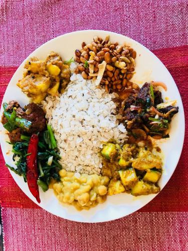 a white plate of food with rice and vegetables at HOTEL RUPAKOT AND ROOFTOP RESTAURANT in Bhaktapur