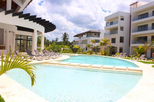 a swimming pool in front of a building at Amar'e Aparthotel & Spa in Las Terrenas