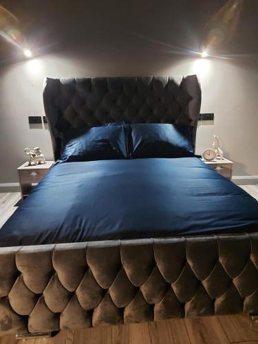 a bedroom with a large bed with a leather headboard at Lough View Lodge in Dunnamanagh